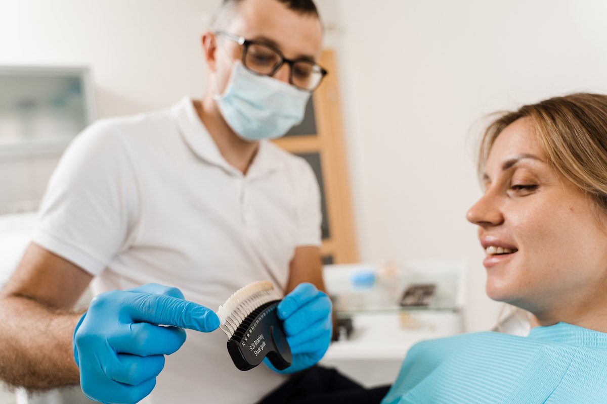 Odontólogo puliendo composite dental a una paciente en consulta