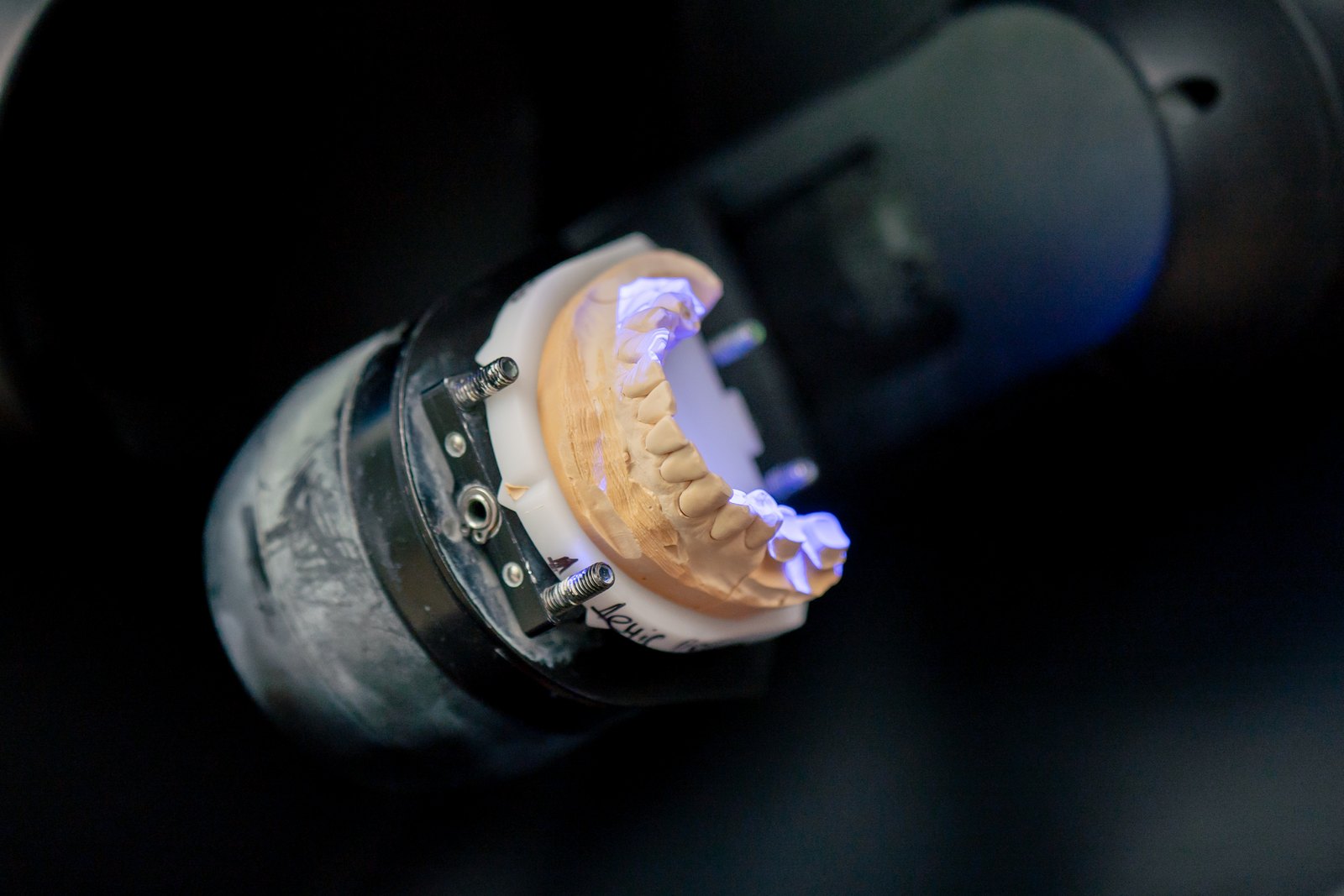 Modelo de yeso de una arcada dental en el escáner de un laboratorio dental, iluminado con luz azul
