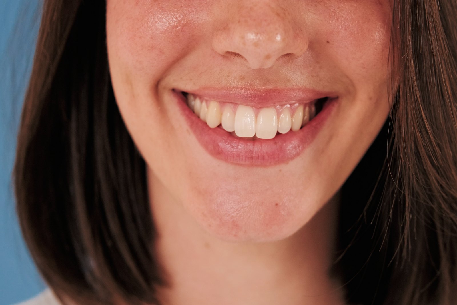 Primer plano de una mujer sonriendo con los dientes superiores a la vista